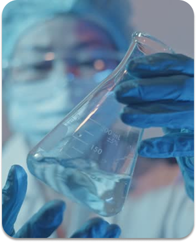 Lab worker in blue gloves handling vials of nasal spray formulation